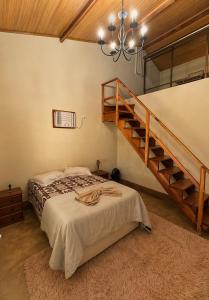 a bedroom with a bed and a staircase at Casa na Serra Canto do Jair in Casimiro de Abreu