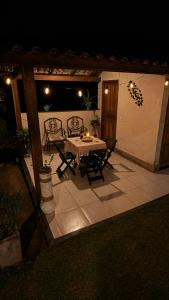 a table and chairs on a patio at night at Casa na Serra Canto do Jair in Casimiro de Abreu +29 photos