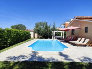 a swimming pool with lounge chairs and a house at Villa Tramonto 4 stars, Krnica in Krnica