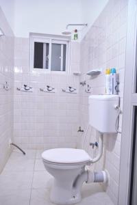 a white bathroom with a toilet and a window at Malindi White in Malindi +18 photos