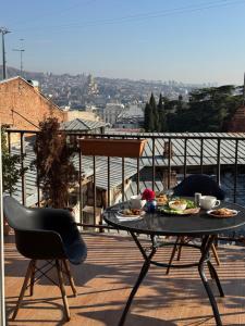 a table with plates of food on a balcony at Hotel "Tbilisi Tales" in the heart of the Old City in Tbilisi City