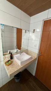 a bathroom with a sink and a mirror at Pousada Beach House Coqueirinho in Jacumã