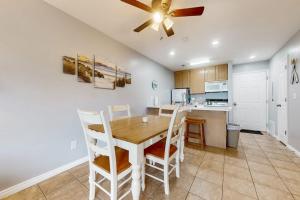 a kitchen with a table and chairs and a ceiling fan at Harbor Village Pool Building Condo 104 in Garden City +9 photos