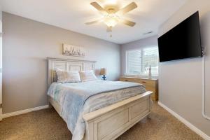 a bedroom with a bed and a flat screen tv at Harbor Village Pool Building Condo 104 in Garden City
