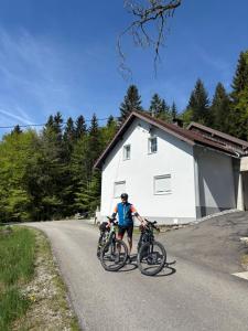 a man riding two bikes on a road at Ferienhaus Plöckenstein in Schwarzenberg am Bohmerwald