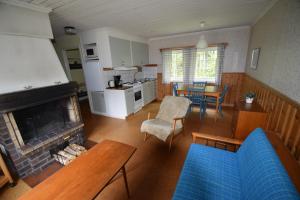 a living room with a couch and a fireplace at Ekesberget Stugby stuga 6 in Ekshärad