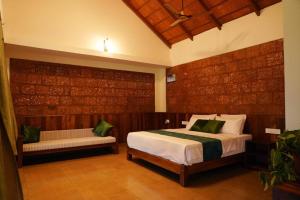 a bedroom with a bed and a bench in it at HighFields Coorg in Virajpet