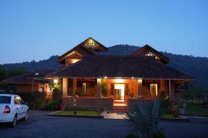 a house with a car parked in front of it at HighFields Coorg in Virajpet