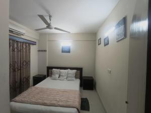 a bedroom with a bed and a ceiling fan at Epindi Studio Apartment in Cox's Bazar