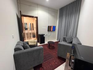 a living room with two couches and a flat screen tv at استديو كلاود in Al Baha +11 photos