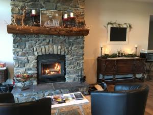 a stone fireplace in a living room with a table and chairs at Timber Baron Inn in Bayfield