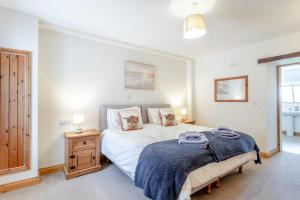 a bedroom with a bed and a dresser with towels on it at 2 Bed in Holsworthy oc-91755 in Holsworthy