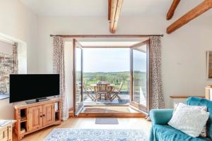a living room with a tv and a sliding glass door at 2 Bed in Holsworthy oc-91755 in Holsworthy