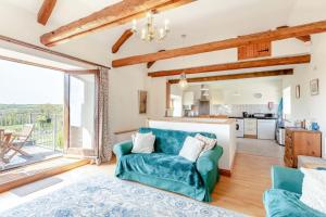 a living room with a blue couch and a kitchen at 2 Bed in Holsworthy oc-91755 in Holsworthy