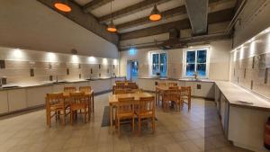 a large kitchen with wooden tables and chairs at 39 Mini Pod "Treene" in Silberstedt