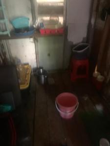 a small room with a red bucket on the floor at Good home in Codrington Village