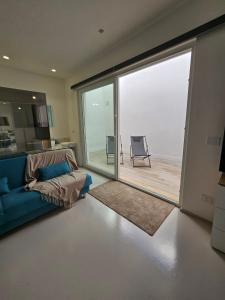 a living room with a blue couch and a sliding glass door at Villa Nilde in Triggianello