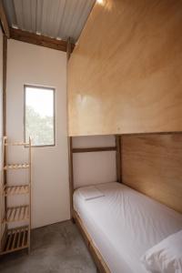 a bunk bed in a small room with a ladder at Ahora Wellness Hostel in Guachaca