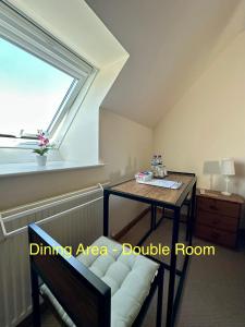 a living area with a table and a window at Feochan Portree in Portree