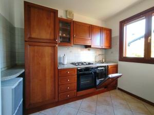 a kitchen with wooden cabinets and a stove top oven at Casa Nicole Aquileia in Aquiléia