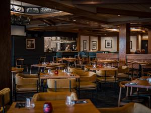 a dining room with tables and chairs and a bar at Chateau Jasper in Jasper