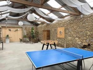 a ping pong table in a room with a stone wall at Maison "Ouessant" Pays des Abers in Plouguerneau