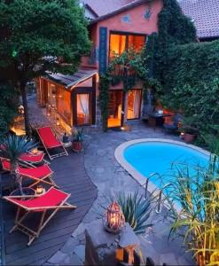 a backyard with a swimming pool and chairs and a house at Ferienhaus-Sauna Pool Whirlpool in Grimma