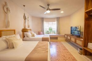a bedroom with two beds and a flat screen tv at Casa Sofía Centro in Mérida