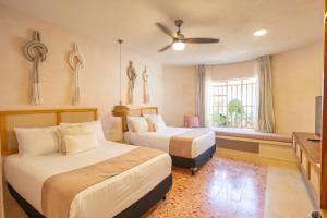 a hotel room with two beds and a television at Casa Sofía Centro in Mérida +100 photos