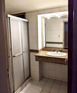 a bathroom with a sink and a mirror at Hotel Armele Asunción in Asunción