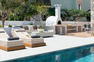 a patio with a pool and furniture next to a swimming pool at Ortus Luxury Residence in Rhodes Town