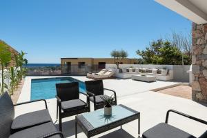 a patio with chairs and a swimming pool at Ortus Luxury Residence in Rhodes Town