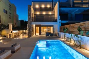 a villa with a swimming pool at night at Ortus Luxury Residence in Rhodes Town +25 photos
