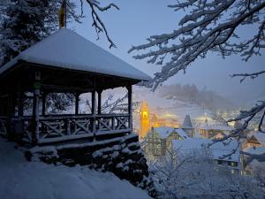 a gazebo covered in snow with a city at Ferienwohnung Bächle in Bad Peterstal