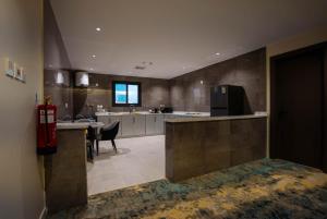 a large kitchen with a counter and a dining room at iqama mumayyaza الإقامة المميزة للشقق المخدومة - إقتصادي in Tabuk