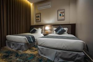 a hotel room with two beds in a room at iqama mumayyaza الإقامة المميزة للشقق المخدومة - إقتصادي in Tabuk +36 photos
