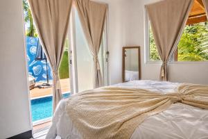 a bedroom with a bed and a view of a pool at La Ceiba Suite 2 with private plunge pool in Anasco