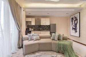 a living room with a couch and a kitchen at Bridge Apartment Lagos in Lekki