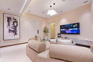 a living room with couches and a flat screen tv at Bridge Apartment Lagos in Lekki