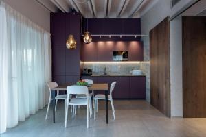 a kitchen with purple walls and a table and chairs at Calle Suite Lazise in Lazise