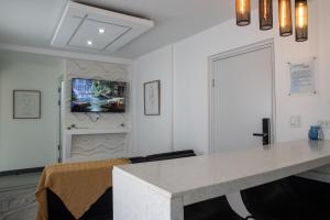 a white room with a table and a tv on the wall at La Ceiba Suite 2 with private plunge pool in Anasco
