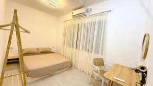 a bedroom with a bed and a desk and a window at Leisure29 Suites - Setali - 7pax in Kuantan