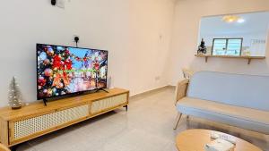 a living room with a flat screen tv and a couch at Leisure29 Suites - Setali - 7pax in Kuantan