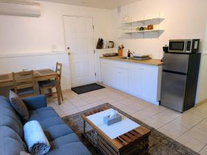 a living room with a blue couch and a kitchen at Ashwood monthly in Courtenay