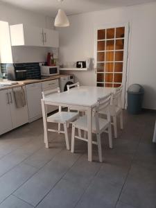 a white table and chairs in a kitchen at Chambres d'hôtes in Annoisin-Chatelans