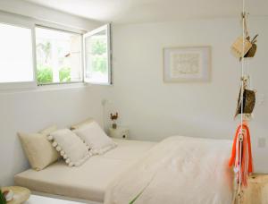a white room with a bed and two windows at #studio 19 in Saint-Léonard