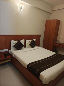 a bedroom with a large bed with black and white pillows at skylink residency in Chennai