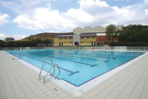 a large swimming pool in front of a building at Apartamento turístico Ana, con garaje y bonitas vistas in Arróniz