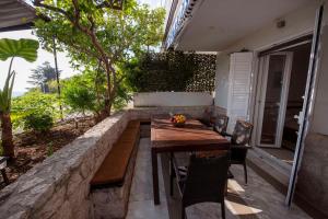 a wooden table and chairs on a patio at Apartments Kalaba - Dalma II in Podaca