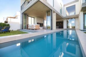 a house with a swimming pool next to a house at Sonvanger Villa Struisbaai in Struisbaai